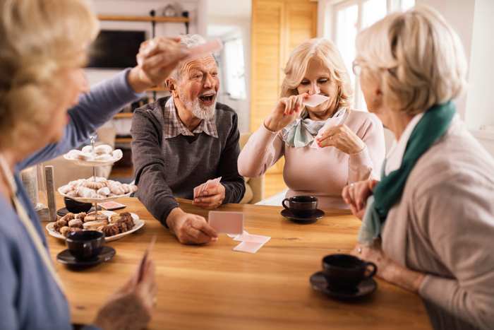Några äldre personer spelar ett livat parti kort.